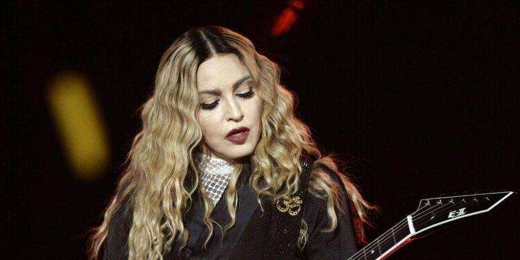 Madonna cade da una sedia sul palco, si rialza e canta