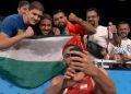 L’atleta iraniano Azar Pira vince la medaglia di bronzo di lotta libera e scatta selfie con bandiera palestinese