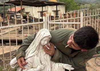 Nuova foto shock, soldato del regime genocida israeliano mette una sigaretta in bocca a statua di Maria