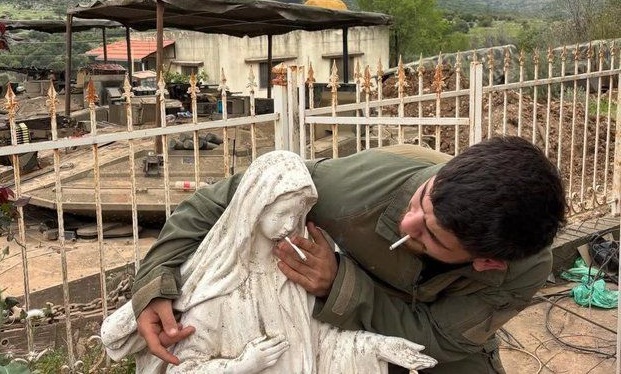 Nuova foto shock, soldato del regime genocida israeliano mette una sigaretta in bocca a statua di Maria